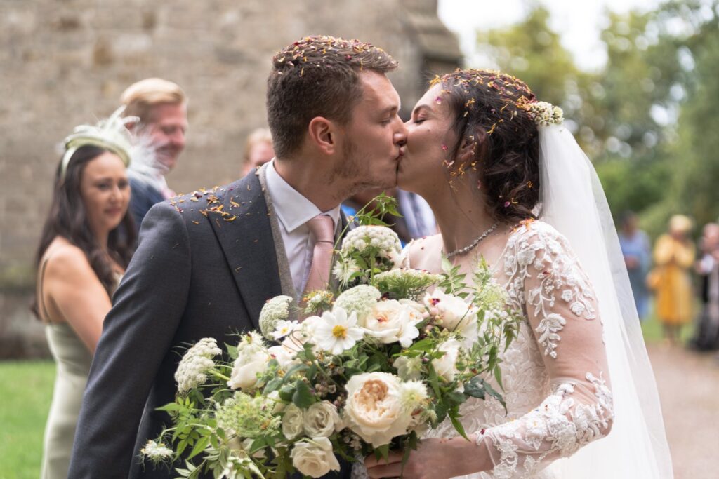 89 confetti covered groom kisses bride st andrews churchyard prestwold leicestershire oxfordshire wedding photography