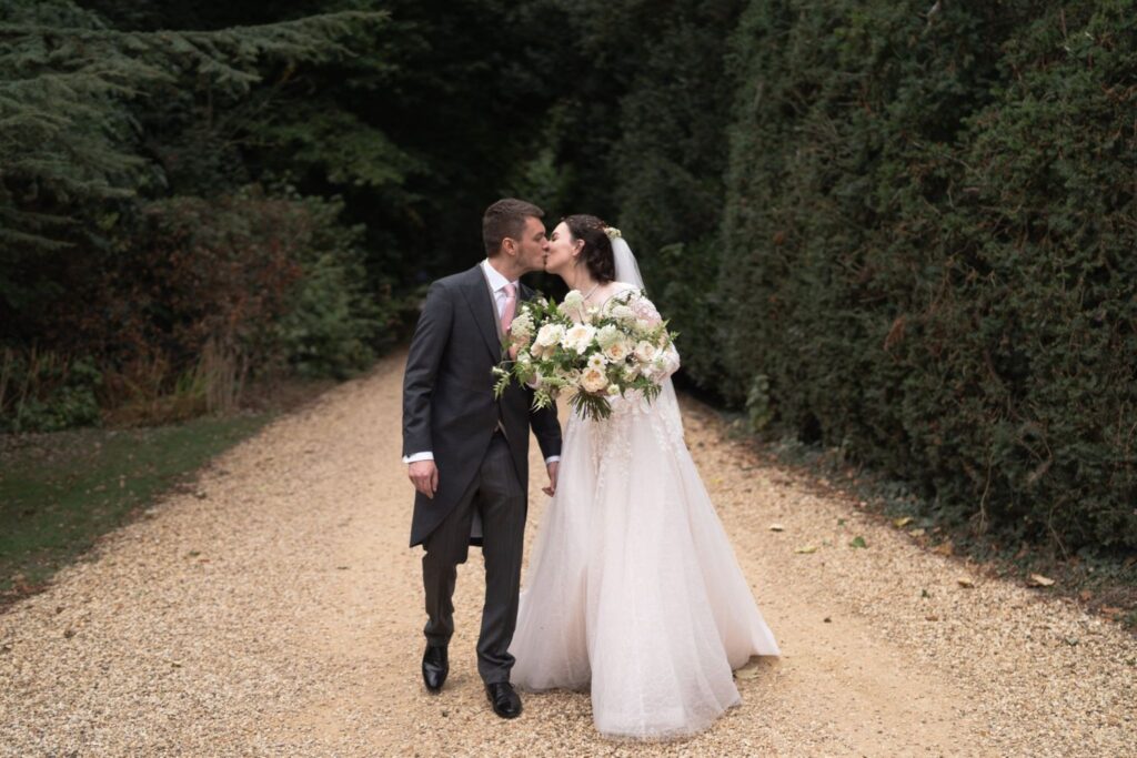 97 bride holding bouquet kisses groom prestwold hall grounds loughborough oxford wedding photographers