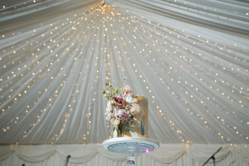 107 cake under marquee fairy lights ardington house reception wantage oxfordshire oxford wedding photographer