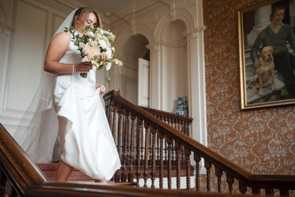 26 bride descends staircase ardington house wantage oxfordshire oxford wedding photographers