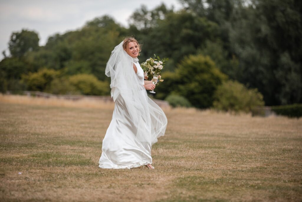 71 smiling bride holding drink bouquet ardington house grounds wantage oxfordshire oxford wedding photographer