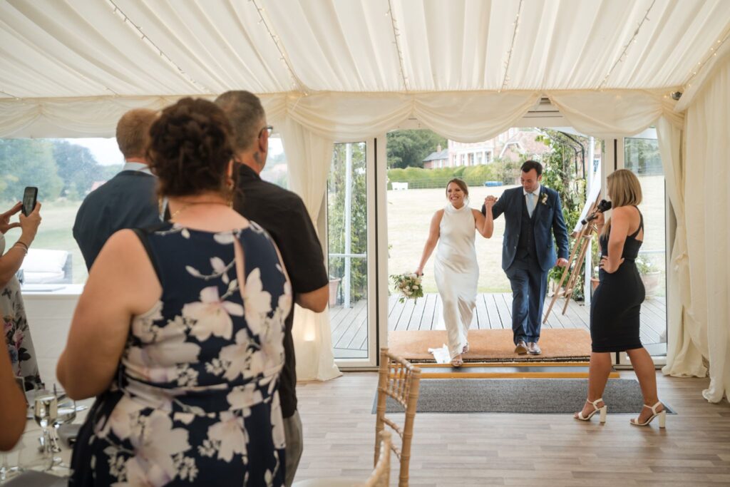 79 bride groom enter reception marquee ardington oxfordshire wedding photographer