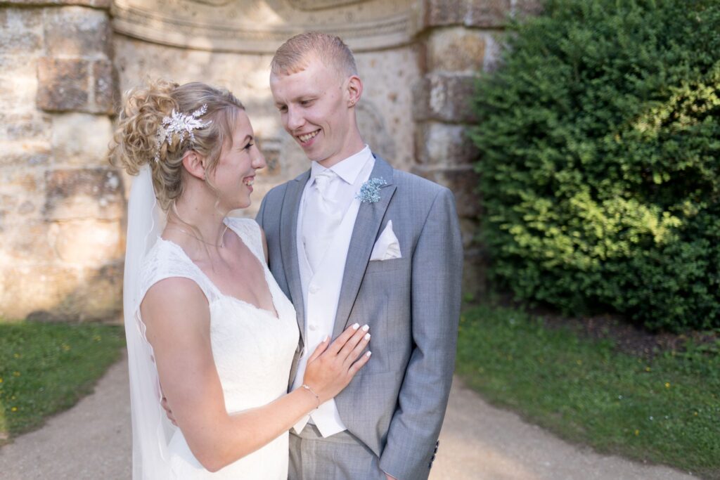 smiling bride groom embrace stowe house gardens buckinghamshire oxfordshire wedding photography
